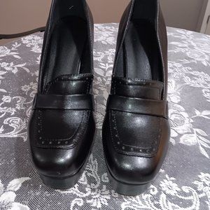 A PAIR OF BLACK LOAFERS WITH HEELS SIZE 8M